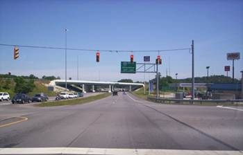 Figure 4.14 shows an example of a roadway that has partial access control (i.e. access via grade-separated interchanges and direct access roadways), which would be identified as a Code '2' for this Data Item.