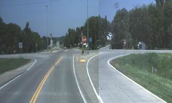 2 lane road with right turn lane and a stop sign controlling left turns