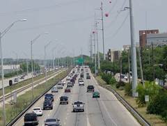 Divided multi-lane highway with a rail line in the center.