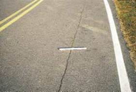 Figure 4.80 shows an example of moderate severity longitudinal cracking (wheel path) on a roadway with an asphalt-concrete (AC) surface.