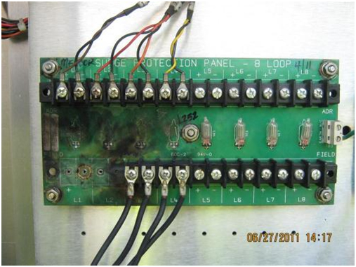 Loop Field Connections Destroyed by Lightning Induced Surge. This photo illustrates the burn damage to the connection panel caused by the referenced lightning strike.