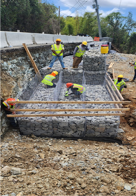 A group of men in safety vests working on a construction site. 