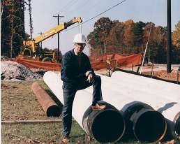 Photo for Utility Design Relocation Design - Man standing next to large pipes