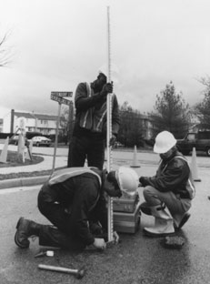 Three utility workers working on test hole