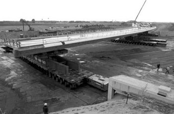 Aerial view of a two-span bridge being moved by an SPMT