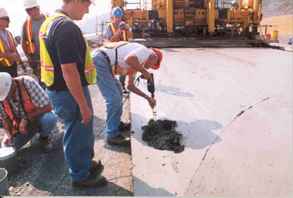 A concrete sample for air void analyzer testing is obtained using a vibrating drill.