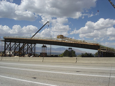 Figure 3. Photo. The superstructure of the new 4500 South bridge during its construction offsite. The superstructure is on scaffolding and a crane is behind it.
