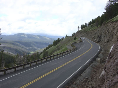 Figure 10. Photo. View of the two-lane Grand Loop Road in Yellowstone National Park. Mountains can be seen in the distance.