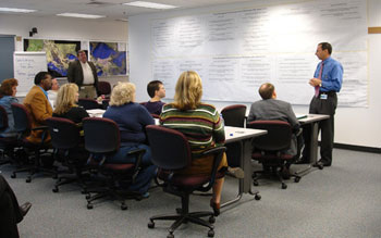 A photo of Louisiana Department of Transportation and Development Secretary Johnny B. Bradberry (right) speaks with team leaders of the department's change management program. This process improvement initiative brings together employees and stakeholders who suggest changes that result in better productivity, winning Louisiana an NPHQ bronze award for Risk Taking.