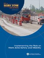 Figure 1. Photo. Cover of Implementing the Rule on Work Zone Safety and Mobility. The cover shows a highway work zone with orange barrels, three workers, and two trucks in the foreground.