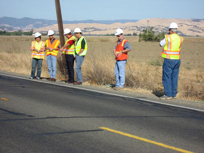 Photo. Caltrans rubberized treatment test site. Six scanning tour team members visit a Caltrans rubberized treatment test site on SR 16 in Yolo County, CA.