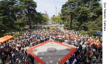 Figure 5. Photo. Three dozen doves are released at the conclusion of the National Work Zone Awareness Week kickoff event in Sacramento, CA. A crowd stands watching as the doves are released.