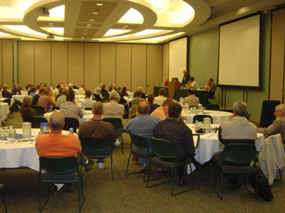 Figure 5. Photo. A view of a room full of participants listening to a question and answer session at the Maintenance Decision Support System Showcase in Omaha, NE.