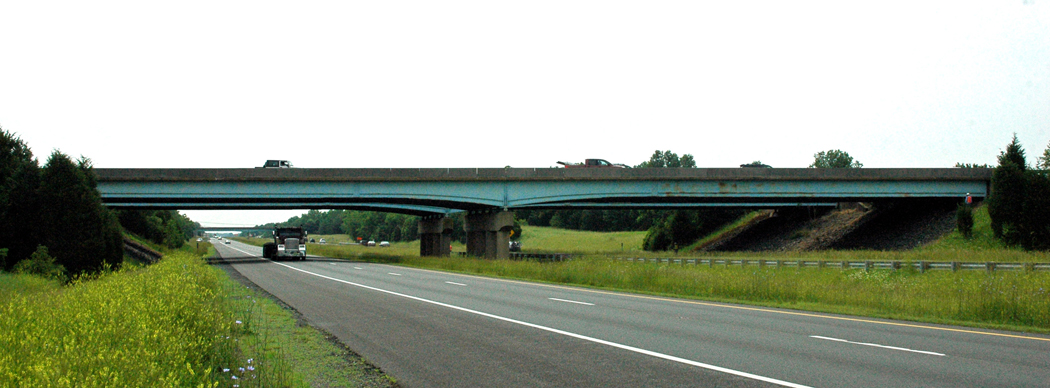 An overpass on U.S. Route 15 over I-66 in Haymarket, VA. Traffic is traveling across the bridge and a truck is visible on I-66 underneath the bridge.