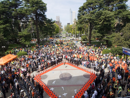 Figure 2. Photo. Three dozen doves are released at the conclusion of the National Work Zone Awareness Week 2008 kickoff event in Sacramento, CA. A crowd stands watching as the doves are released.