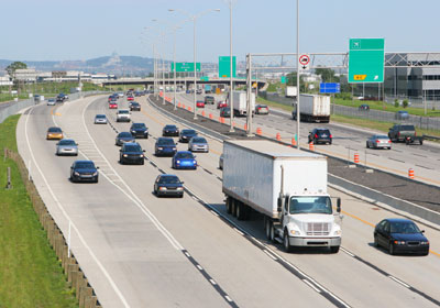 A view of oncoming traffic merging onto a three-lane highway.