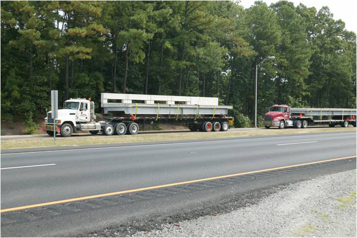 Two tractor-trailer trucks haul prefabricated bridge segments to be used in the rehabilitation of a bridge on Route 15/29 in Prince William County, VA.