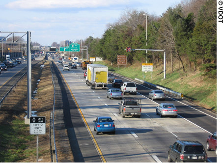 A view of the four-lane I-66 in Fairfax County, VA. Cars, trucks, and other vehicles are traveling on the Interstate.