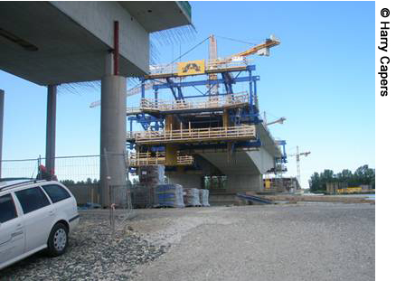  A view of the construction of the Route S33 Bridge over the Danube River in Austria. Scaffolding and a crane are visible.