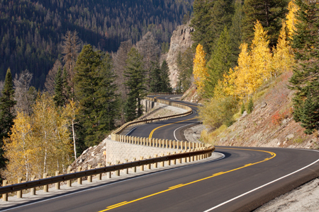 The East Entrance Road to Yellowstone National Park in Wyoming, which was paved in 2007 using warm mix asphalt. In the background are mountainous wooded areas.