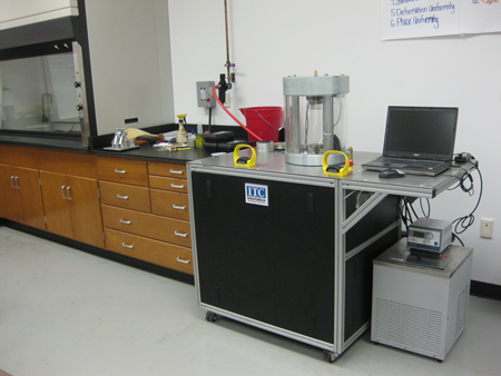 Figure 4. Photo. An asphalt mixture performance tester (AMPT) in a laboratory. The AMPT can subject a compacted asphalt mixture specimen to cyclic loading over a range of temperatures and frequencies.
