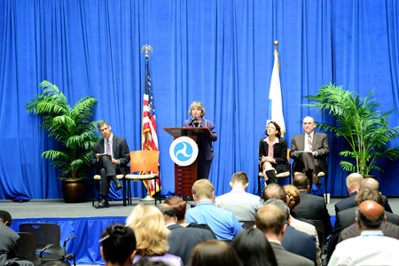Bryna Helfer, Director of Public Engagement at the U.S. Department of Transportation (USDOT), stands at a podium featuring the USDOT logo while addressing audience members at Data Palooza on May 9, 2013, in Washington, DC.