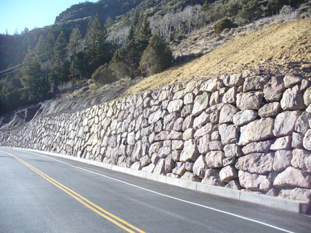 A close-up view of a rockery on the right-hand side of Beaver to Junction Highway in southern Utah. The rockery contains stacked angular rocks. Above the rockery is a wooded slope.