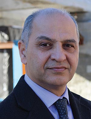 This image is a headshot of Dr. Hamid Ghasemi, the team leader of the Infrastructure Management Team in the Office of Infrastructure, Research, and Development at FHWA.