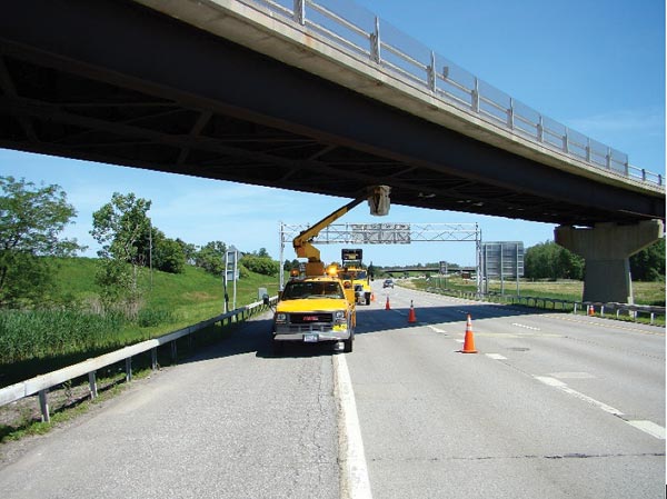 This image shows a typical field evaluation using a bucket truck (snooper) underneath the bridge. Evaluations focus on two cross-sections. One above the shoulder and the other above the right traffic lane, where the percentage of truck traffic is typically the highest.