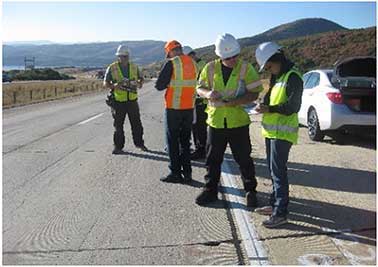 This photograph is of five Long-Term Pavement Performance distress raters evaluating concrete pavement on US-40 in Park City, UT. The source credit line reads “Source: FHWA.”