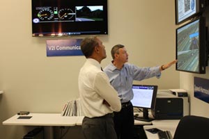 Director of Operations Research and Development Joe Peters explains the high-tech nature of vehicle-to-infrastructure communications and how the technology will one day help save lives and reduce congestion (left). During the visit to the Saxton Transportation Operations Laboratory, which houses the equipment needed for testing vehicle-to-infrastructure communications, Taylor Lochrane shared research details with the President. 