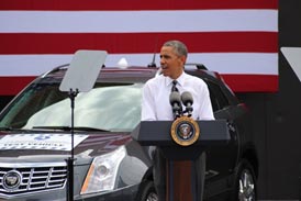 The President stands in front of three test vehicles as he speaks to the employees at FHWA.