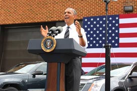 The President stands in front of three test vehicles as he speaks to the employees at FHWA.