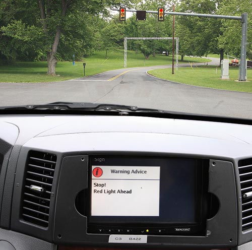 An advisory message, “Stop! Red Light Ahead,” appears on a display on the dashboard in the Cooperative Vehicle-Highway test vehicle as it approaches the intelligent intersection at Turner-Fairbank. The message is an example of a real-time safety alert that could be provided to motorists.