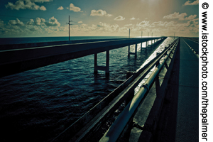 Photo. Long bridge over water in the Florida Keys, backlit by the sun.