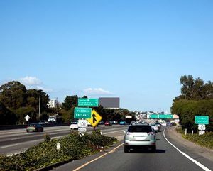 Photo. An in-car view of traffic merging onto a freeway.