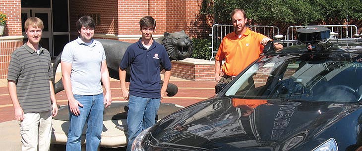 A group photo of the Auburn University research team. The research vehicle is pictured in the foreground with a roof-mounted camera.