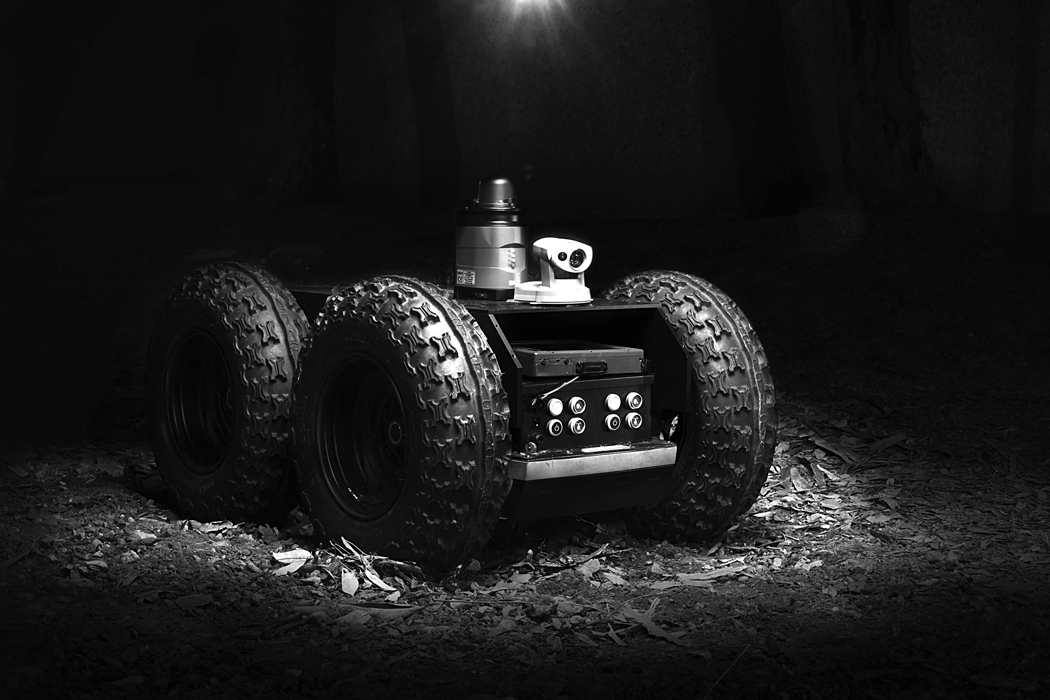 Figure 8. Photo. A product shot of a 5D Robotics vehicle featuring a modified Segway system. The vehicle features four all-terrain wheels, a control box and Web camera mounted on top.