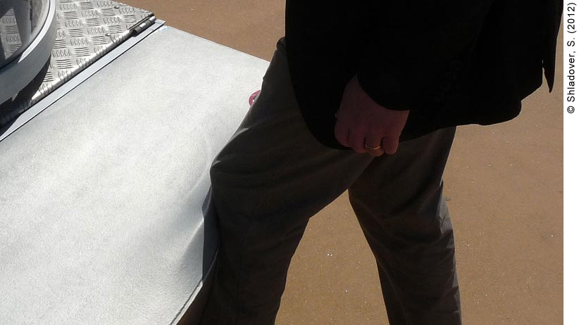 The soft bumper of a 22-passenger CyberCar. A man is pressing his shin against the bumper of the CyberCar; the bumper is giving way to the pressure of the man’s leg and is squishing against it. 