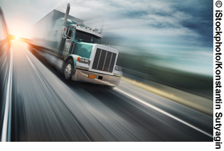A motion-blurred photo shows a truck driving on a highway.
