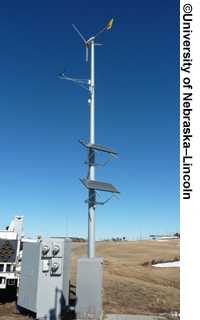 A pole is shown with solar panels and wind-powered equipment mounted at various points.