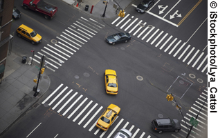 A photo shows a birds-eye view of a several cars negotiating an intersection.