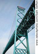 Figure 2. Photo. A view looking up from the ground at a steel bridge.