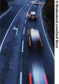 Nighttime time-lapse photo of traffic on a multilane highway.