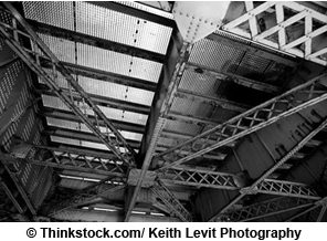 Photo. Partial view of the understructure of a steel bridge from below.
