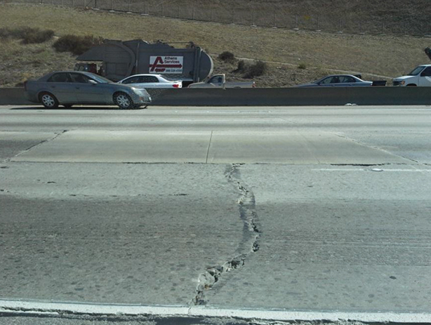 Photo of pavement slabs on the Pomona Highway (also known as California SR 60). This section of the Pomona Highway was constructed the year before the photo was taken, but there is already evidence of joint spalling and cracking (there is a large irregular crack in the roadway surface in the foreground of the photo). 