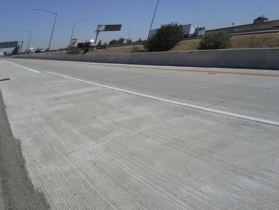 Photo of the Route 60W/71S interchange in Los Angeles. The highway does not have any traffic on it and the roadway surface is in good condition after 17 years of use.