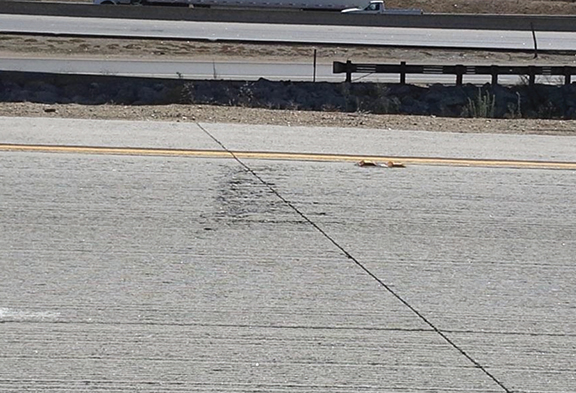 Photo of Route 60W/71S interchange in Los Angeles. There appears to be a long, straight crack in the roadway surface that extends across all of the lanes. This defect is likely due to a placing or finishing issue and not the result of wear. 