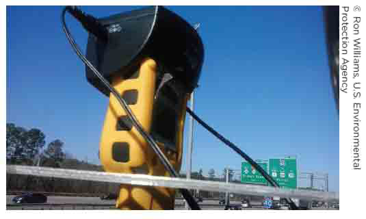 Photo of a portable air quality sensor that has been placed near a highway. This sensor is designed to monitor industrial hygiene volatile organic compounds and is one of the types of sensors funded by the EPA's Air Pollution Monitoring for Communities Grant.