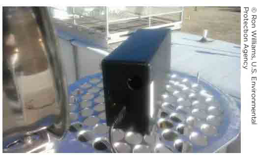 Photo of a portable air quality sensor placed near a highway and designed to monitor air particulates that are the result of transportation-related activities.